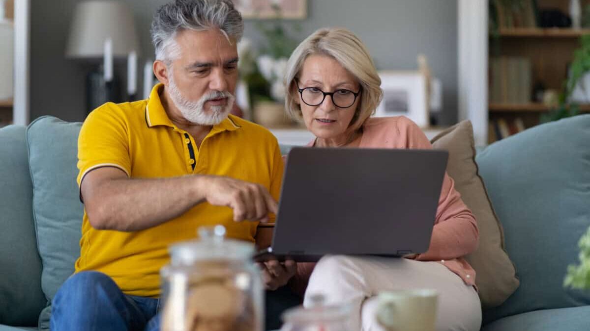 middle-aged couple work together on laptop